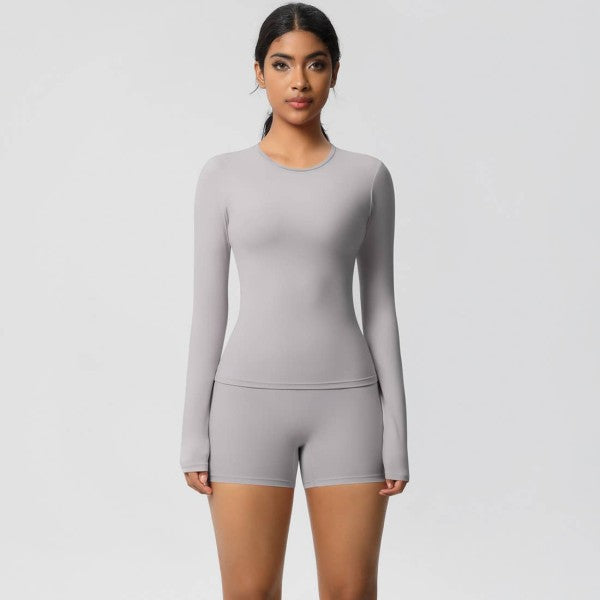 A person in gray fitness attire stands against a plain white background.