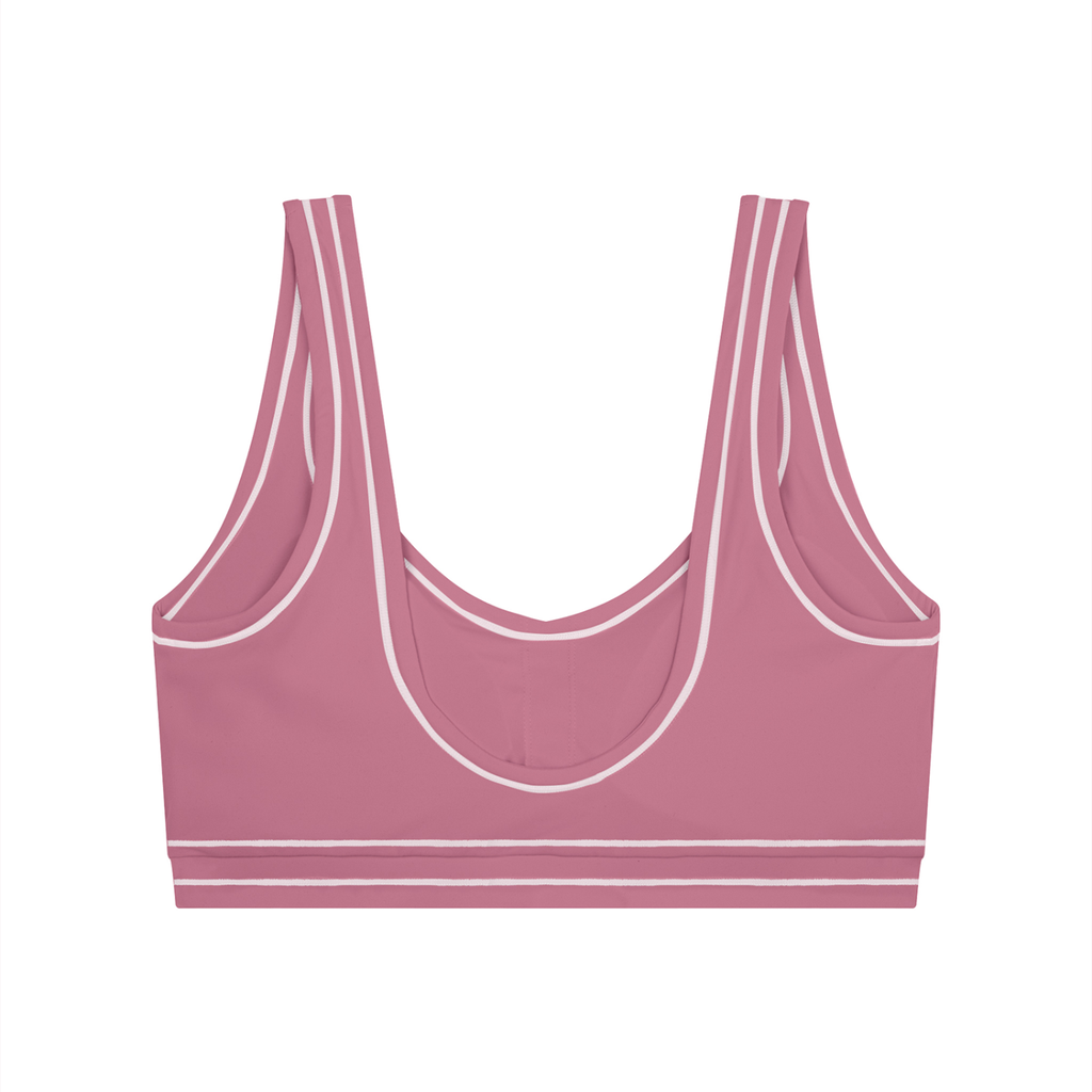 Pink sports bra with white piping and double straps on a white background.