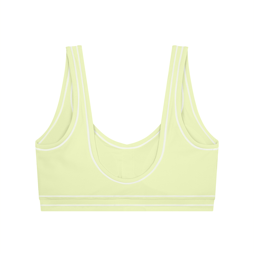 Light yellow sports bra with double straps and white trim on a white background.
