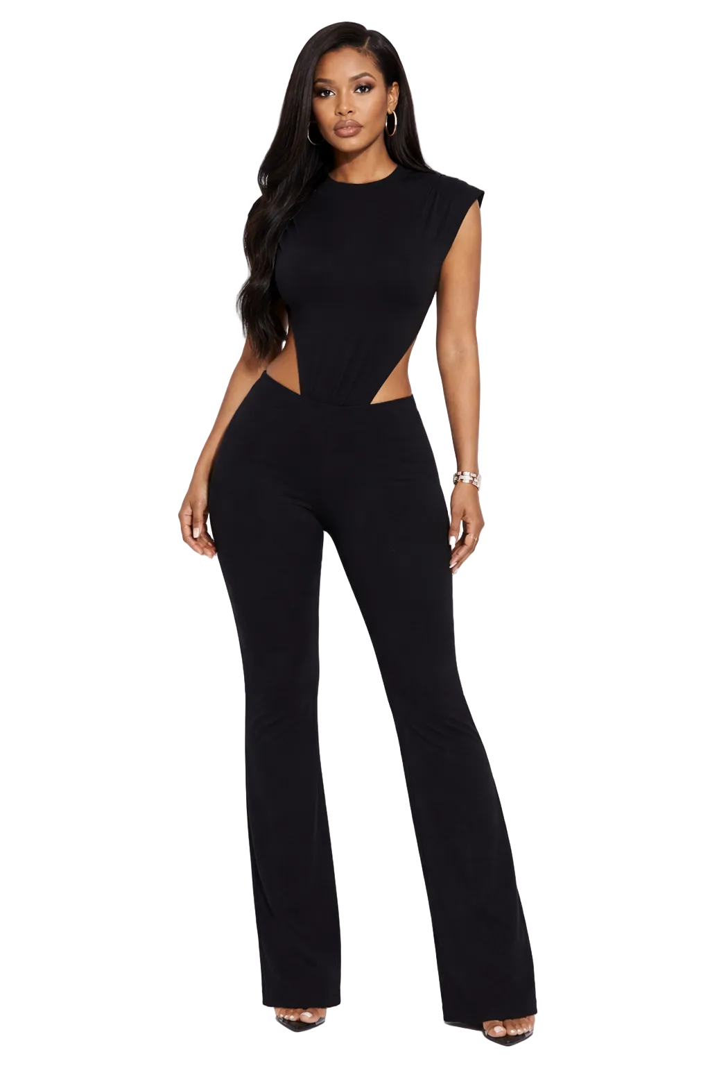 Woman wearing a black jumpsuit with cutouts, long hair, hoop earrings, and high heels.