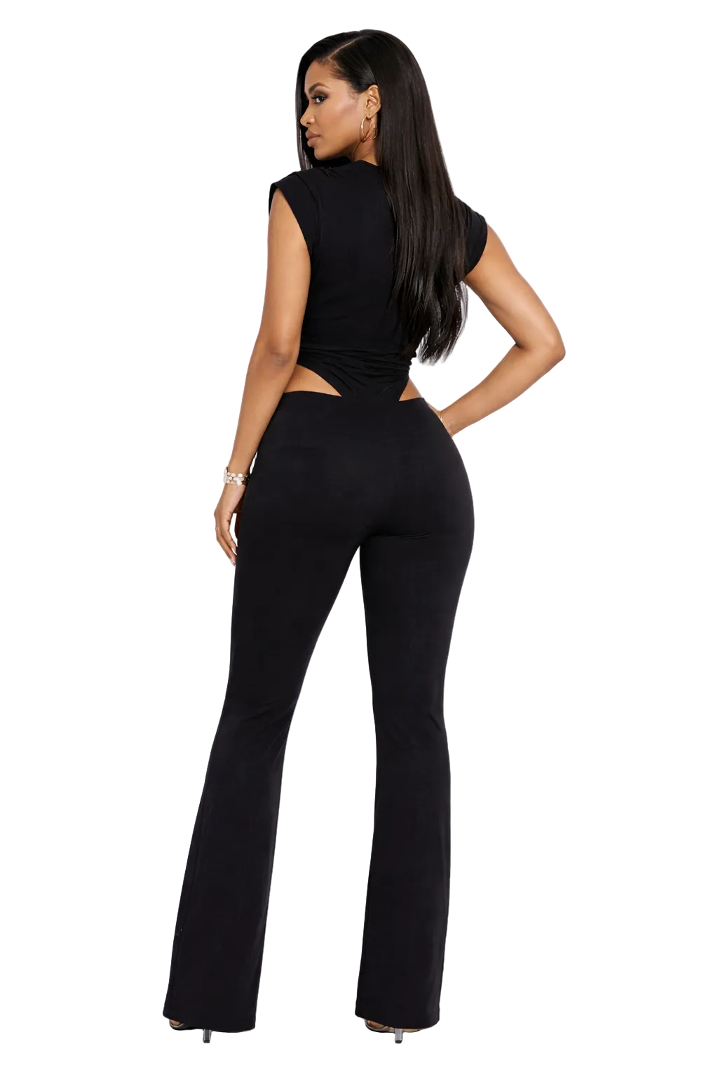 Woman in a sleek black outfit with cut-out design, long hair, and heels, facing away.