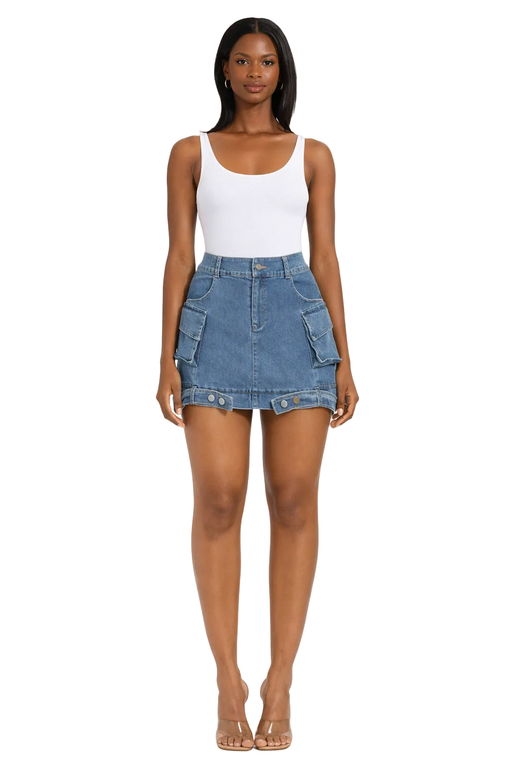 Woman in white tank top, denim skirt with pockets, and clear heels, standing on a white background.