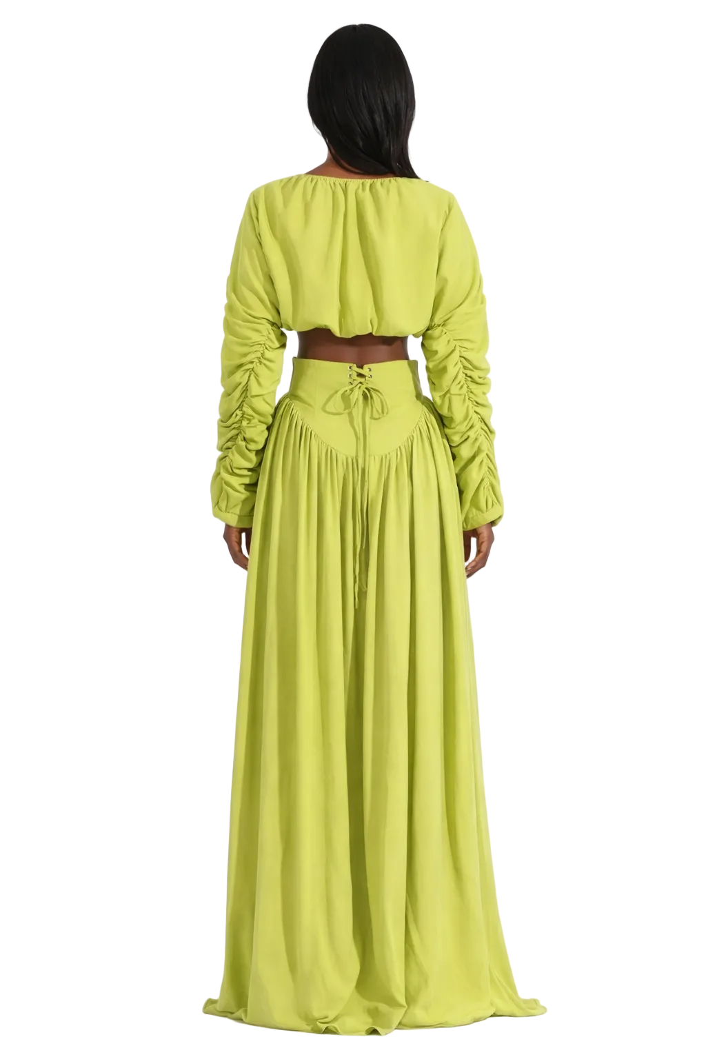 Back view of a woman in a lime green, ruched-sleeve crop top and long, flowing skirt.