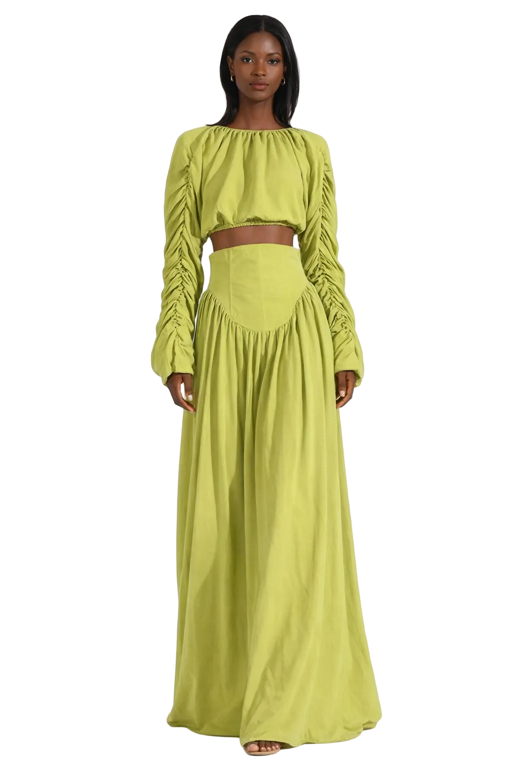 Woman in a lime green crop top and maxi skirt with ruched long sleeves.