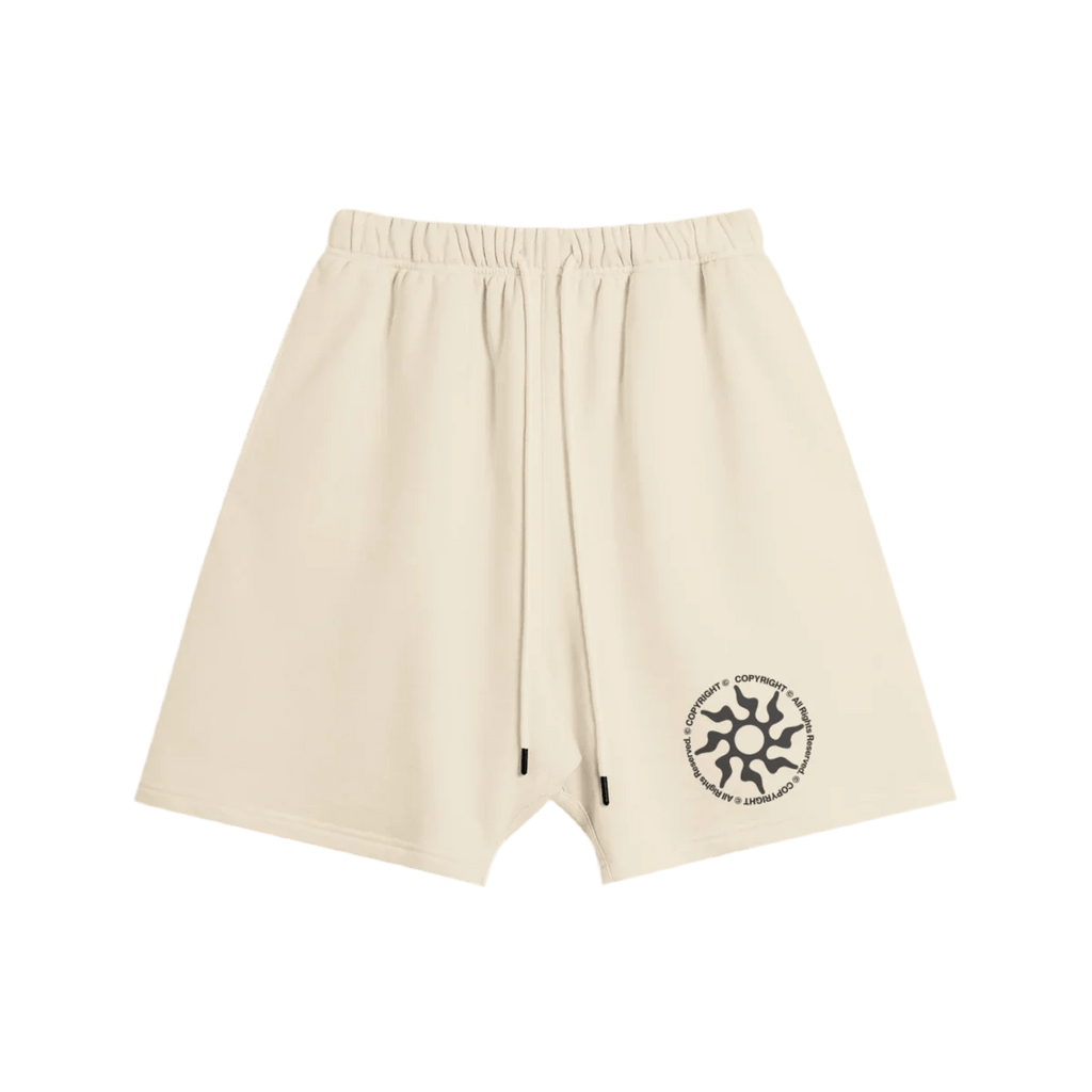 Cream shorts with elastic waistband and drawstrings, featuring a black circular logo on the left leg.