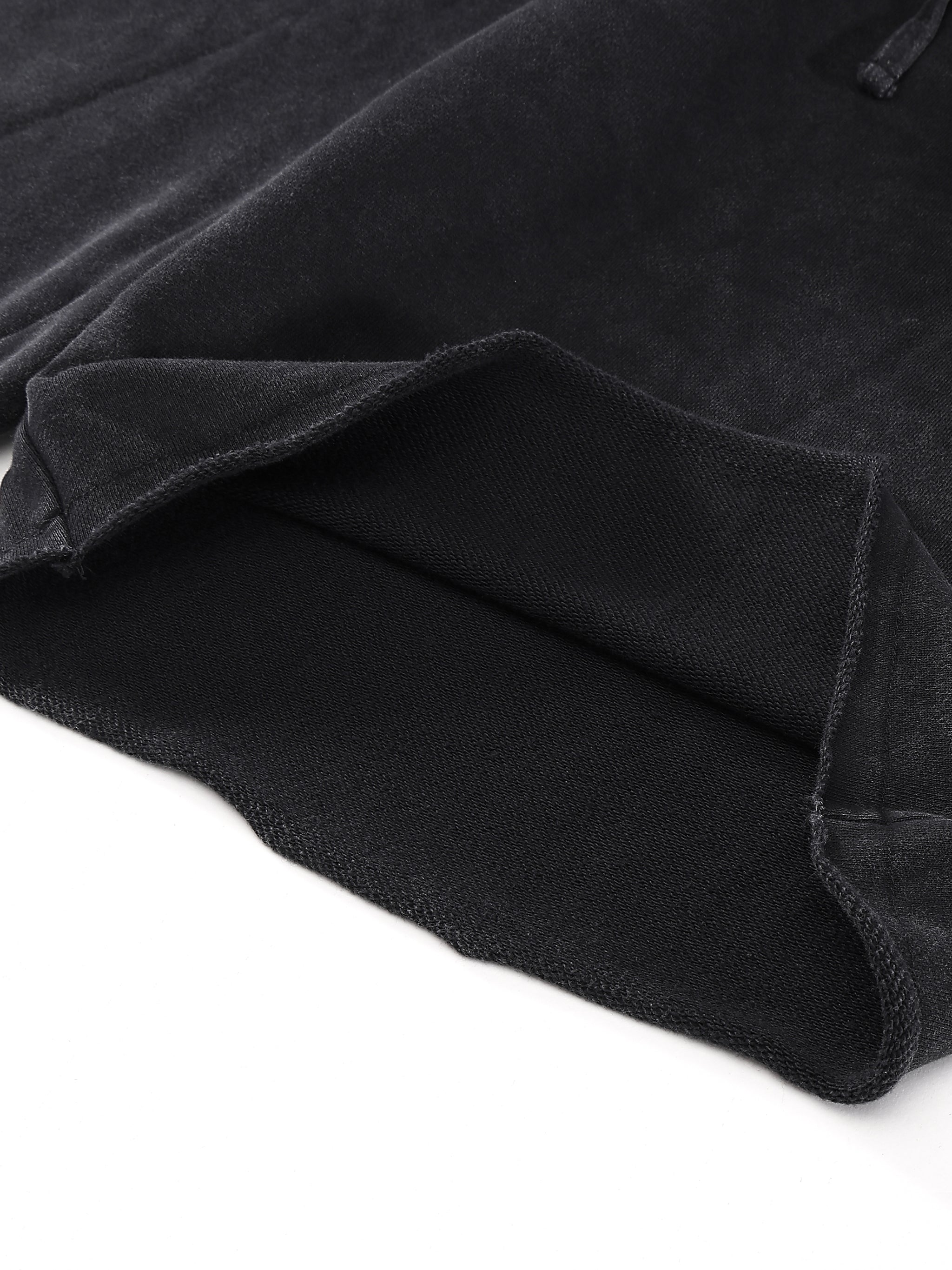 Close-up of black fabric with a folded edge, showing texture and stitching details.