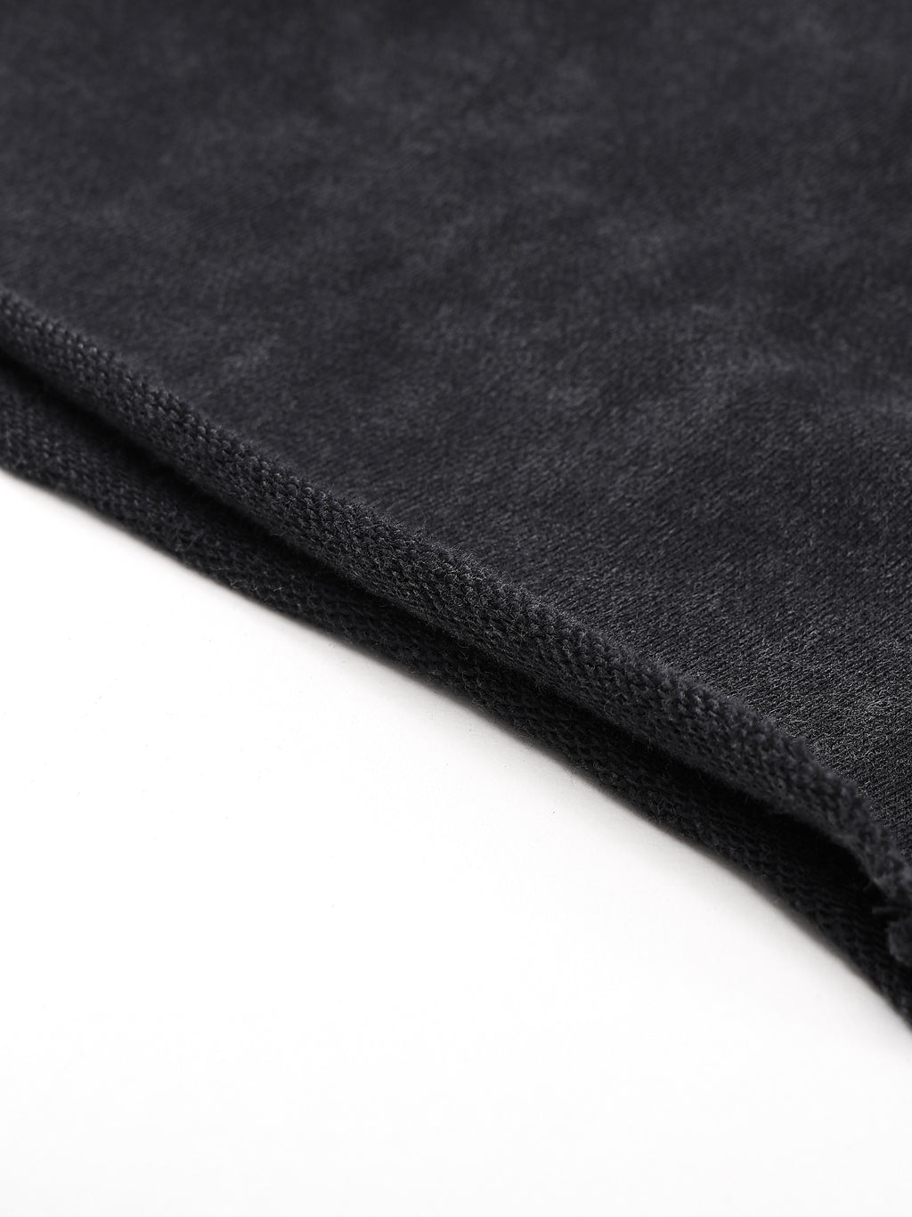 Close-up of dark gray textured fabric with a folded edge on a white background.