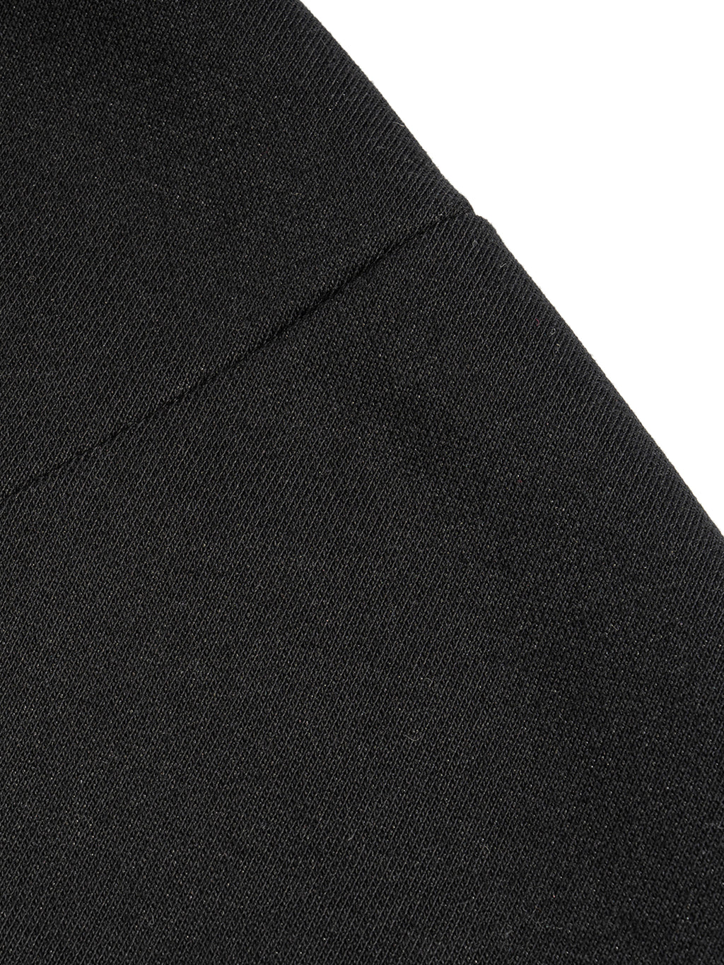 Close-up of a black fabric texture with a diagonal seam, showing fine knit details.