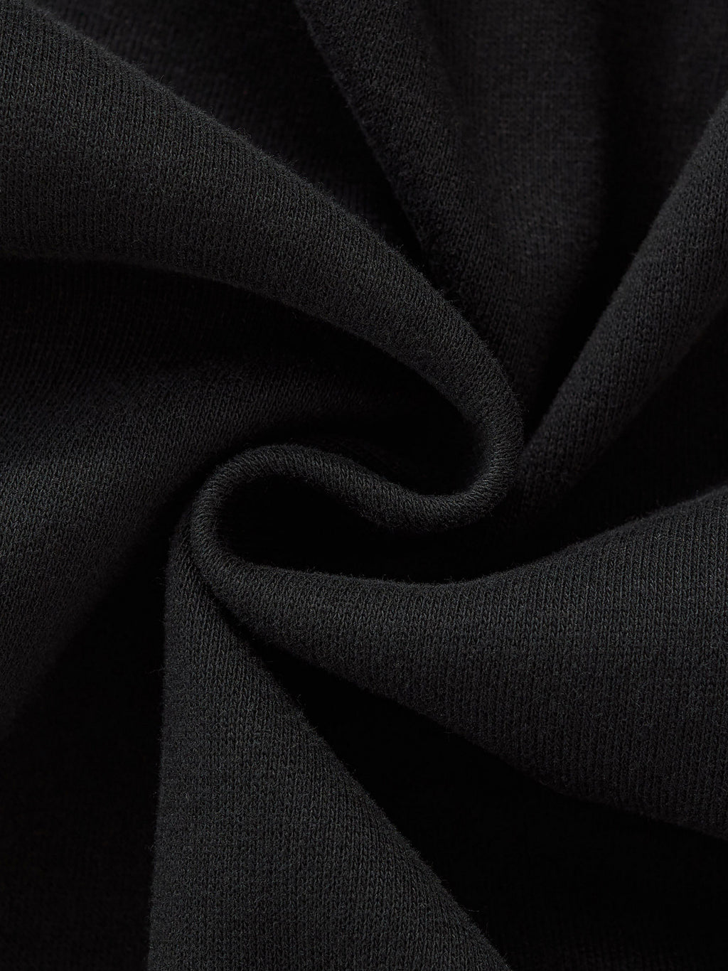 Close-up of black fabric twisted in a spiral, showcasing its soft texture and dark color.