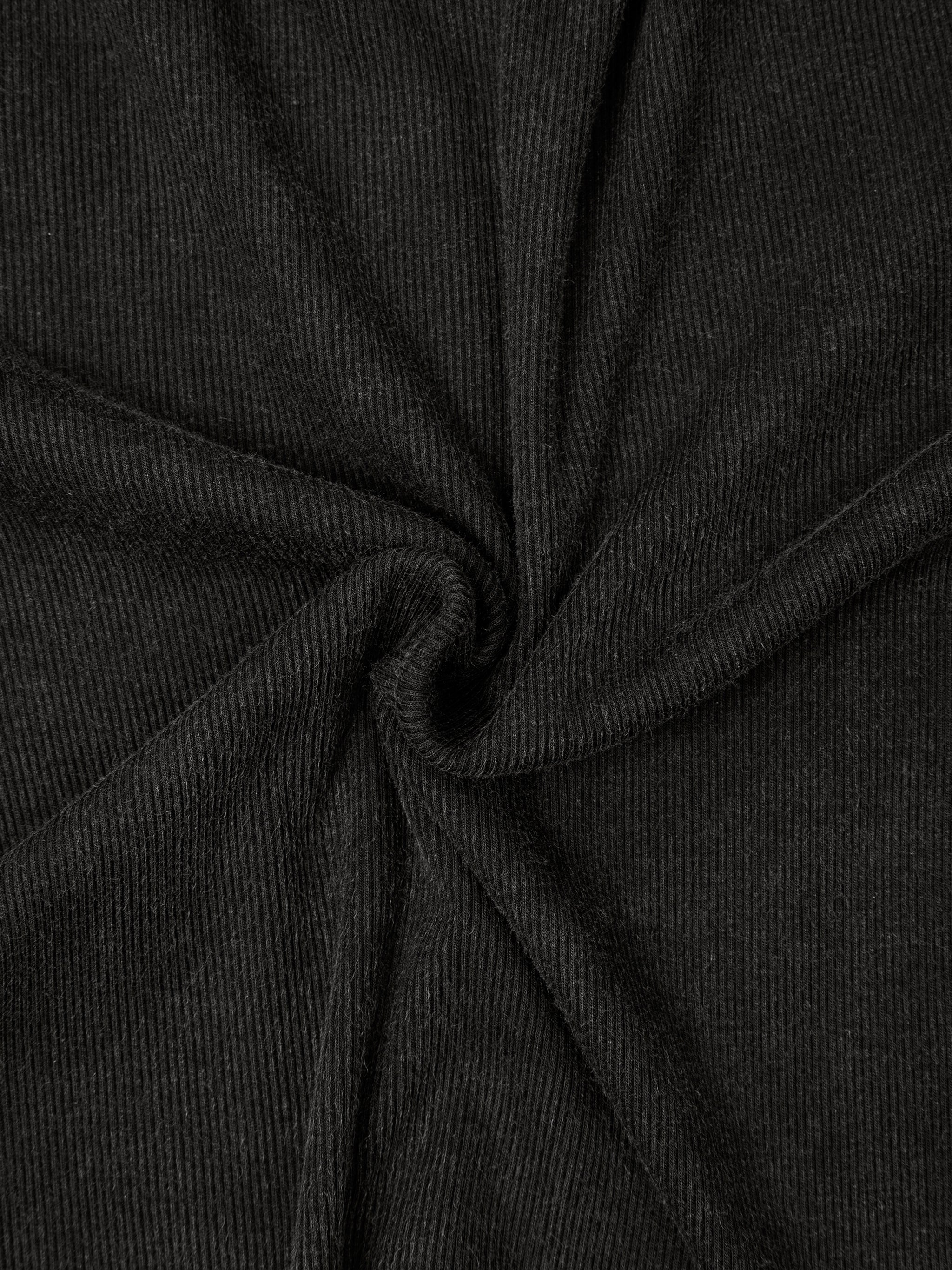 Close-up of black ribbed fabric with a twisted center, showing texture and shadow details.