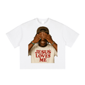 Smiling person in a cap, covering eyes, wearing a "Jesus Loves Me" shirt, colorful bracelets.