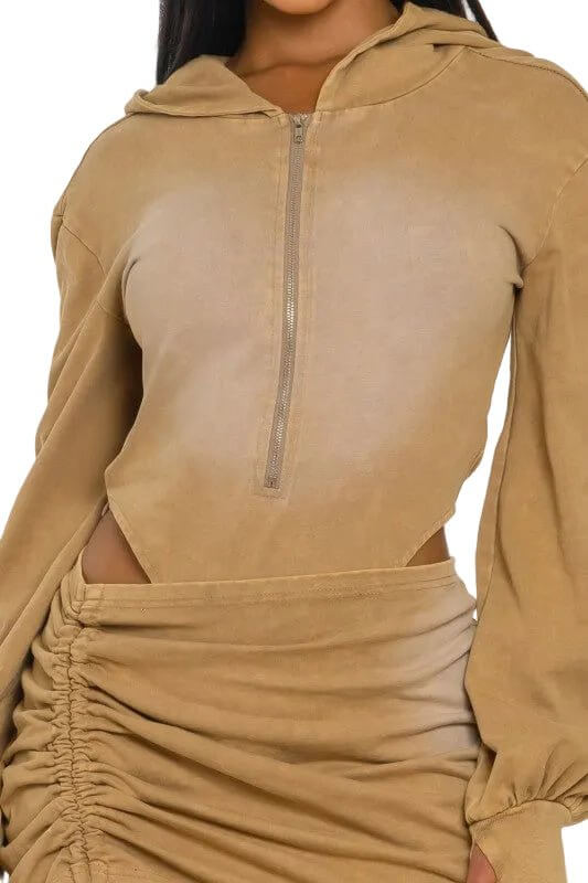 Tan hooded top with front zipper and matching ruched skirt, featuring long sleeves.