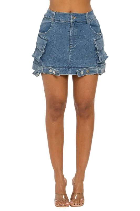 Woman wearing a blue denim mini skirt with large side pockets and a buttoned front.